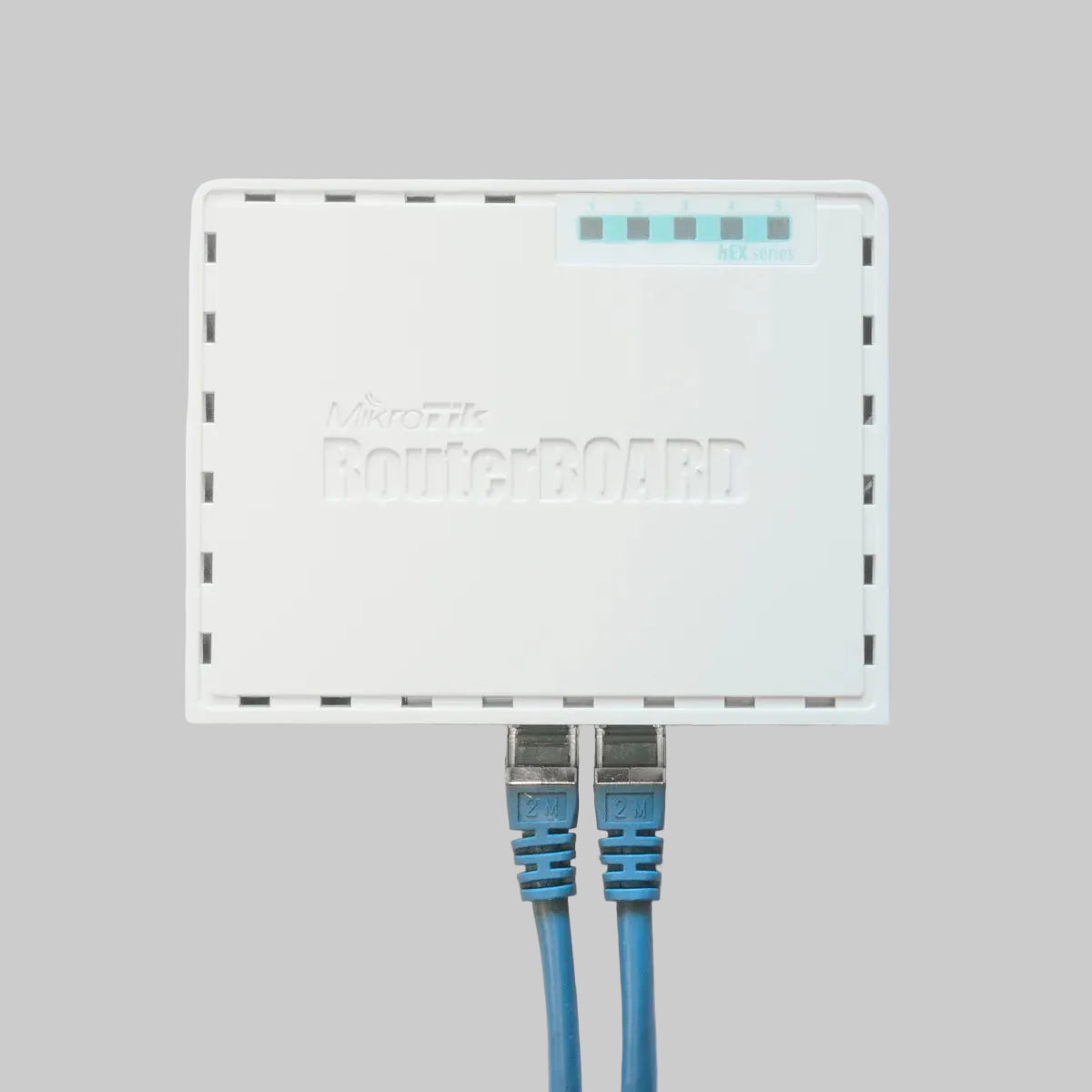 Router MikroTik hEX RB750GR3 blanco con cables Ethernet conectados para red Gigabit empresarial