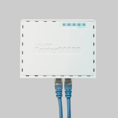 Router MikroTik hEX RB750GR3 blanco con cables Ethernet conectados para red Gigabit empresarial