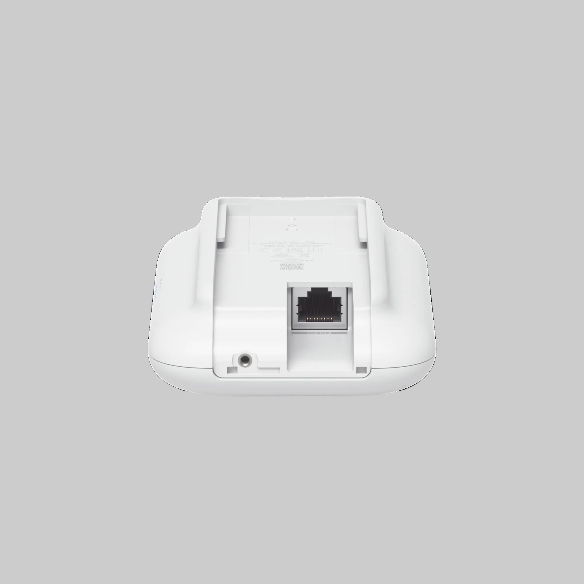 Detalle inferior del UniFi UK-Ultra con puerto Ethernet PoE y conector auxiliar en carcasa blanca
