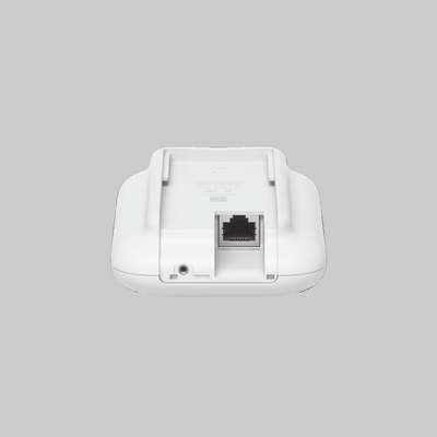 Detalle inferior del UniFi UK-Ultra con puerto Ethernet PoE y conector auxiliar en carcasa blanca